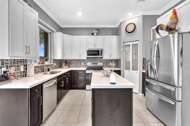 7738 NW 17th Pl, Pembroke Pines, FL 33024 - kitchen with appliances with stainless steel finishes, a sink, light countertops, a kitchen island, and crown molding