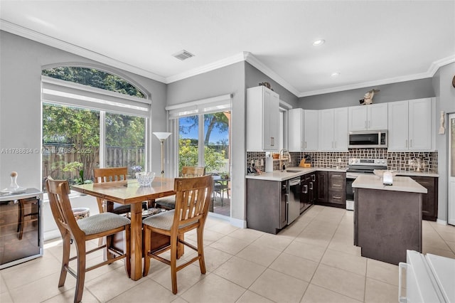 7738 NW 17th Pl, Pembroke Pines, FL 33024 - kitchen with stainless steel appliances, light countertops, a sink, tasteful backsplash, and a kitchen island