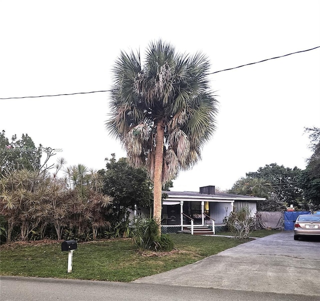 view of front of house featuring driveway and a front lawn