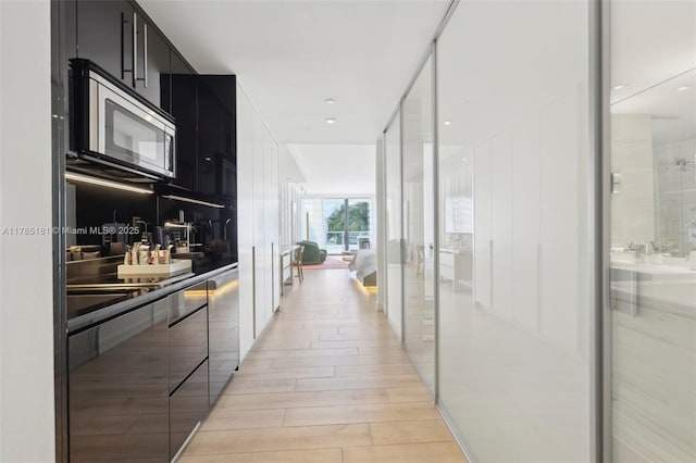 corridor featuring light wood-type flooring and expansive windows