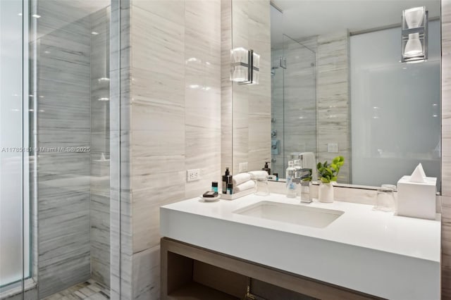 bathroom featuring tile walls, a shower stall, and vanity