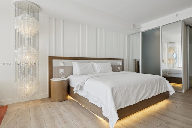 bedroom with a chandelier and wood finished floors