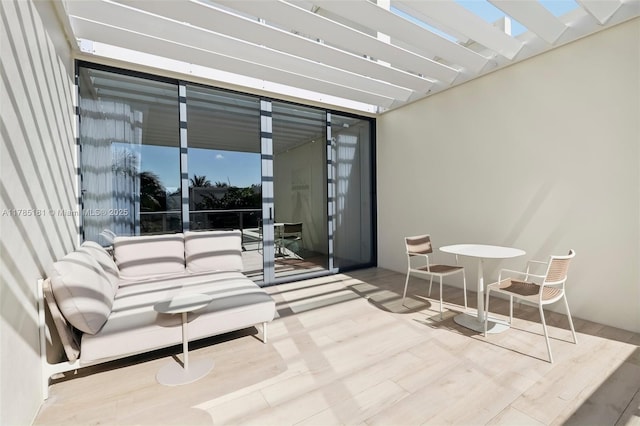 view of patio featuring a pergola and a balcony