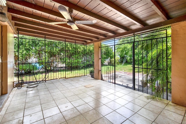 unfurnished sunroom featuring beam ceiling