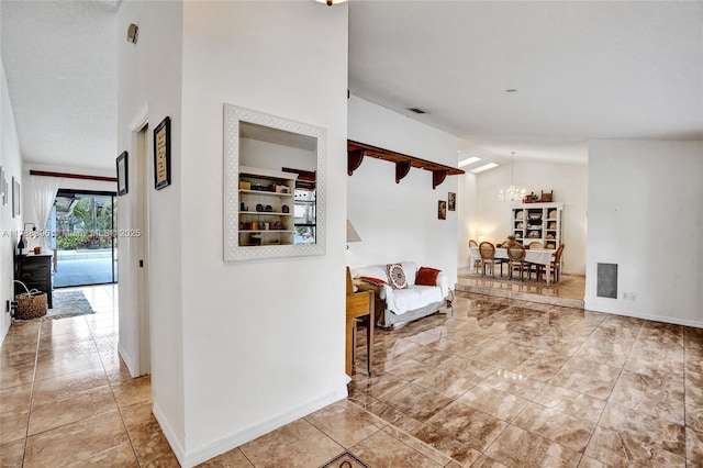 entrance foyer featuring high vaulted ceiling, baseboards, a notable chandelier, and visible vents
