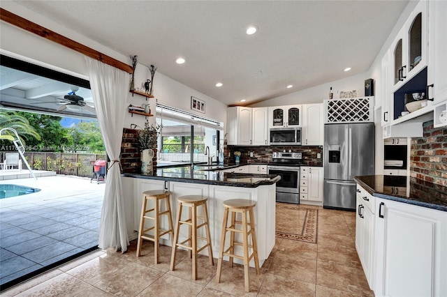 kitchen featuring open shelves, stainless steel appliances, a peninsula, and backsplash