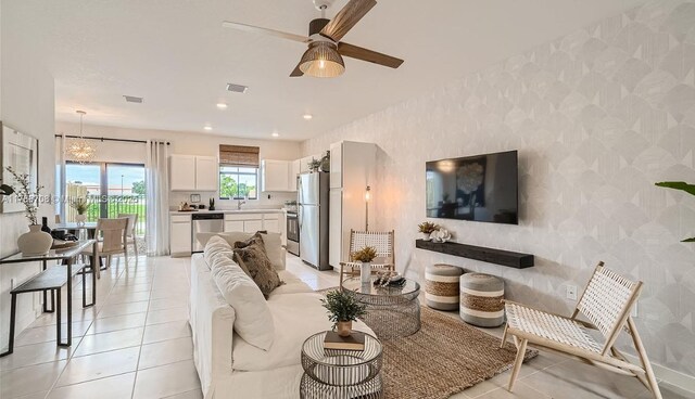 1454 NE 3rd Ave, Florida City, FL 33034 - living area featuring wallpapered walls, visible vents, light tile patterned floors, and ceiling fan with notable chandelier