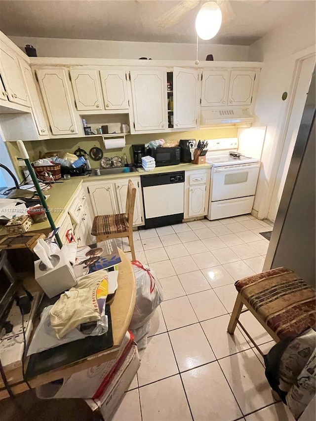 kitchen with white cabinets, white appliances, light countertops, under cabinet range hood, and light tile patterned floors