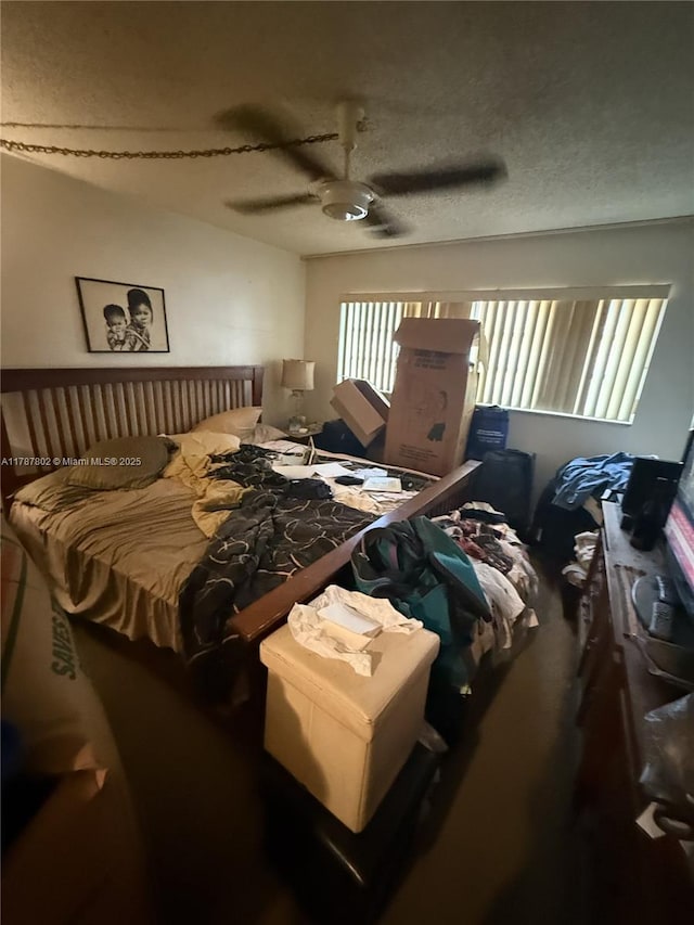 bedroom with a ceiling fan and a textured ceiling