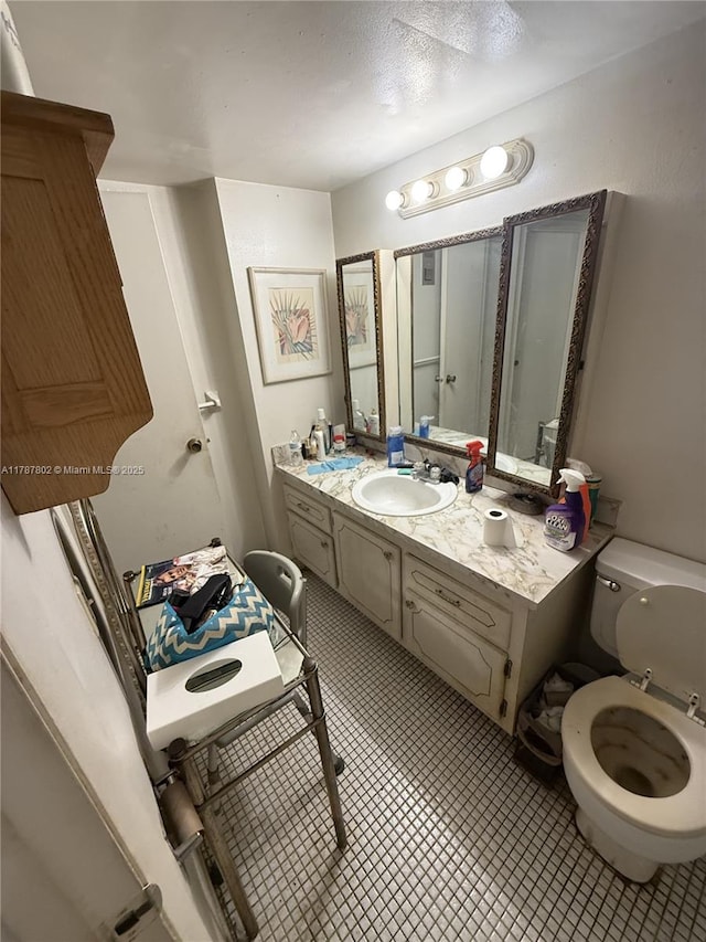bathroom with vanity, tile patterned flooring, and toilet