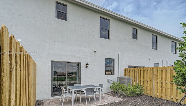1472 NE 3rd Ave, Florida City, FL 33034 - rear view of house featuring stucco siding, central AC unit, a patio, and a fenced backyard