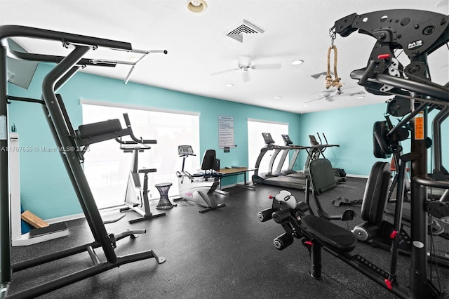 gym with visible vents, a ceiling fan, and baseboards