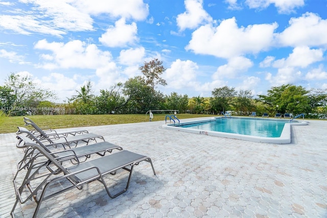 pool featuring a yard and a patio