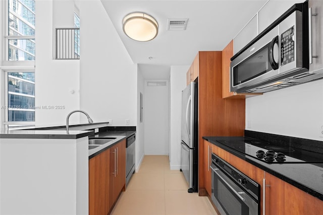 300 S Biscayne Blvd Unit L-802, Miami, FL 33131 - kitchen featuring stainless steel appliances, brown cabinetry, modern cabinets, a sink, and dark countertops