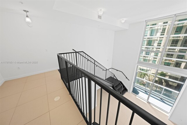 300 S Biscayne Blvd Unit L-802, Miami, FL 33131 - stairway with floor to ceiling windows, baseboards, and tile patterned floors