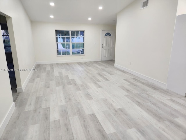 empty room with recessed lighting, light wood-type flooring, visible vents, and baseboards