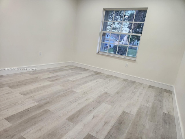empty room with baseboards and wood finished floors