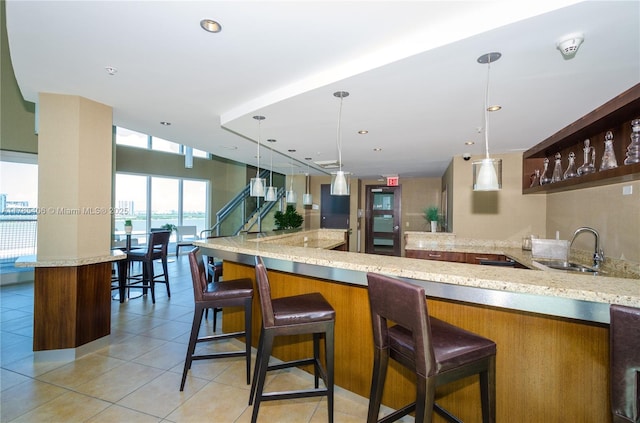 60 SW 13th St Unit 2609, Miami, FL 33130 - kitchen featuring light tile patterned floors, light stone countertops, pendant lighting, recessed lighting, and a breakfast bar