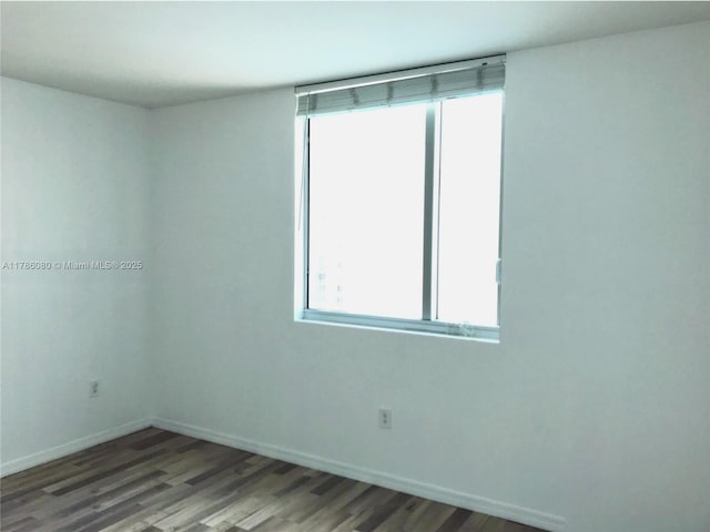 empty room featuring baseboards and wood finished floors