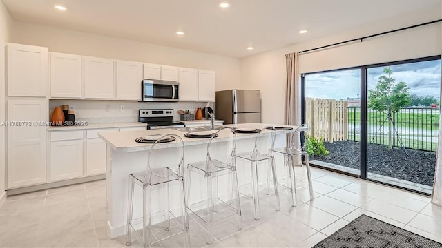 1326 NE 3rd Ave, Florida City, FL 33034 - kitchen with white cabinets, an island with sink, stainless steel appliances, and light countertops