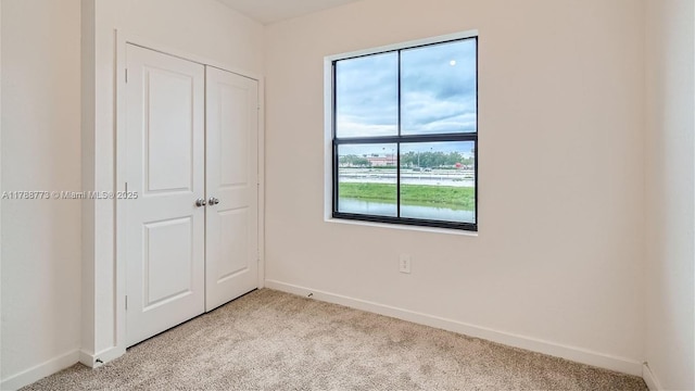 1326 NE 3rd Ave, Florida City, FL 33034 - unfurnished bedroom with baseboards, a closet, and light colored carpet