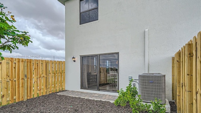 1326 NE 3rd Ave, Florida City, FL 33034 - rear view of property featuring stucco siding, central air condition unit, and fence