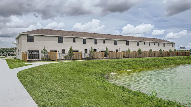 1326 NE 3rd Ave, Florida City, FL 33034 - exterior space featuring stucco siding, fence, a water view, and a yard