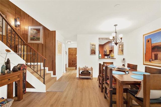 3904 Estepona Ave Unit 8D2, Doral, FL 33178 - dining space featuring stairway, wood finished floors, a chandelier, wood walls, and baseboards