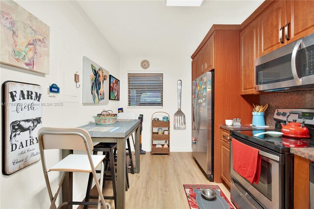 3904 Estepona Ave Unit 8D2, Doral, FL 33178 - kitchen with stainless steel appliances, light wood-style floors, and brown cabinets