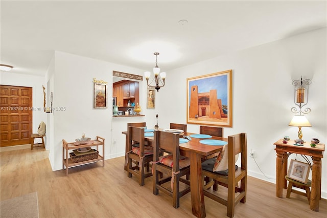 3904 Estepona Ave Unit 8D2, Doral, FL 33178 - dining area with a chandelier, light wood-style flooring, and baseboards