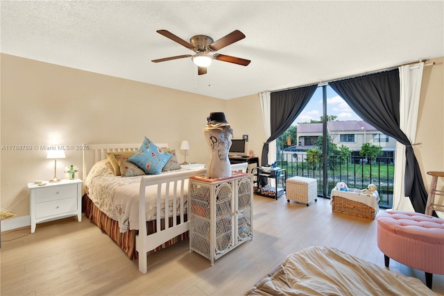 3904 Estepona Ave Unit 8D2, Doral, FL 33178 - bedroom with light wood-type flooring, access to exterior, a textured ceiling, a ceiling fan, and baseboards