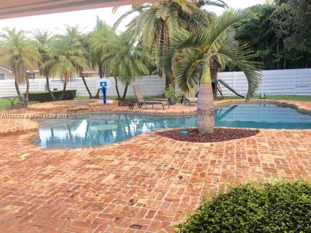 pool featuring a patio and fence