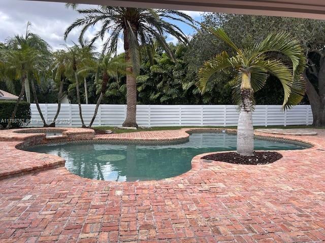 15242 SW 147th Ter, Miami, FL 33196 - view of swimming pool with a fenced backyard, a patio area, and a pool with connected hot tub