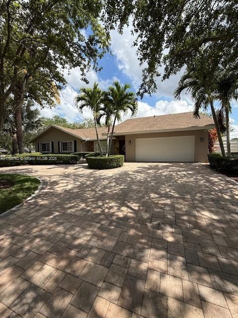 15242 SW 147th Ter, Miami, FL 33196 - ranch-style house with decorative driveway, a garage, and stucco siding