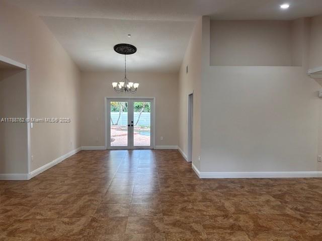 15242 SW 147th Ter, Miami, FL 33196 - unfurnished room featuring a chandelier, baseboards, french doors, and lofted ceiling