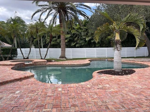 15242 SW 147th Ter, Miami, FL 33196 - view of swimming pool featuring a fenced backyard, a patio, and a pool with connected hot tub