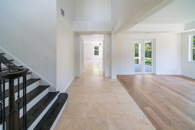 foyer entrance with visible vents, baseboards, and stairs