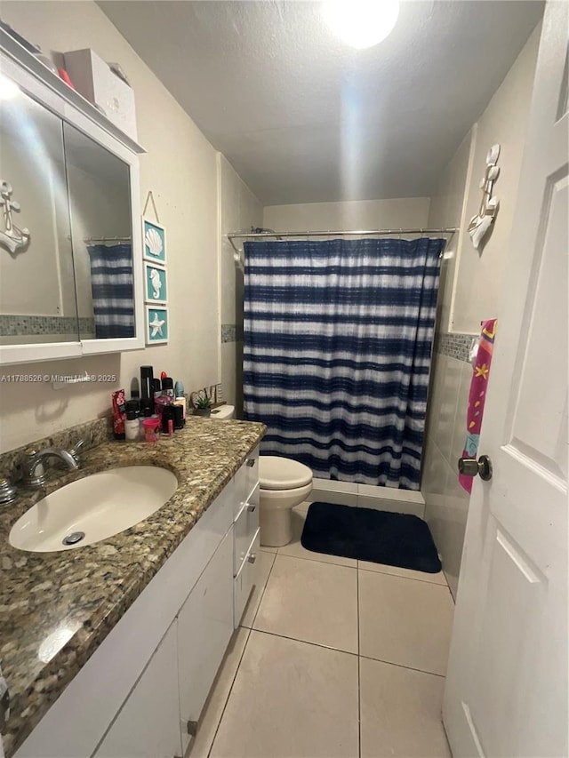 full bath featuring curtained shower, tile patterned floors, vanity, and toilet