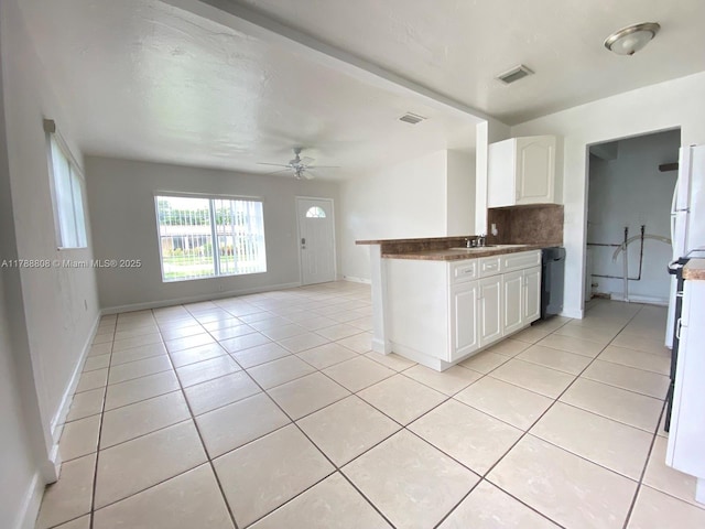 kitchen with visible vents, a ceiling fan, open floor plan, and white cabinetry