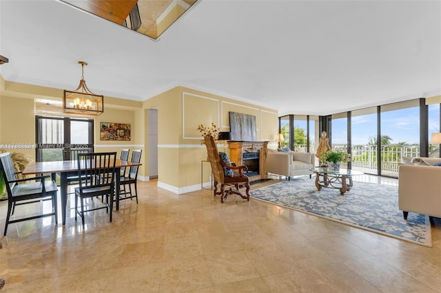 2000 Towerside Ter Unit 702, Miami, FL 33138 - living room featuring crown molding, a fireplace, expansive windows, baseboards, and an inviting chandelier