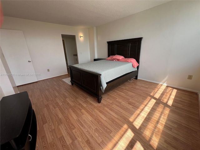 bedroom featuring light wood-style flooring and a textured ceiling
