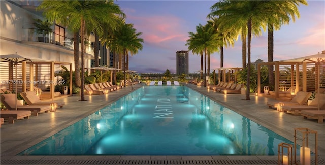 pool at dusk featuring a fire pit, a community pool, and a patio