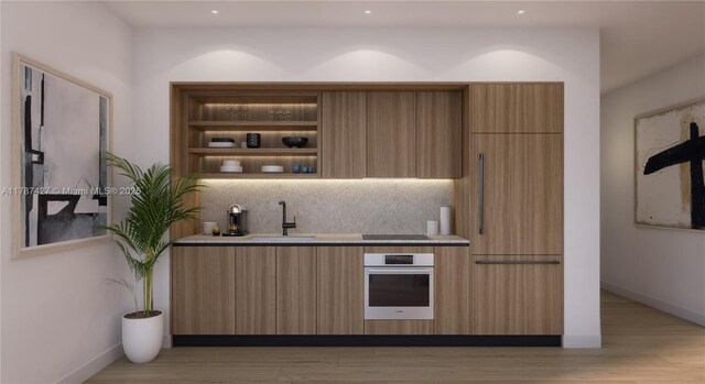 200 W Broward Blvd Unit 2602, Fort Lauderdale, FL 33301 - kitchen with a sink, decorative backsplash, oven, light wood-style floors, and modern cabinets