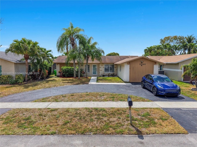 ranch-style house featuring driveway and a front yard