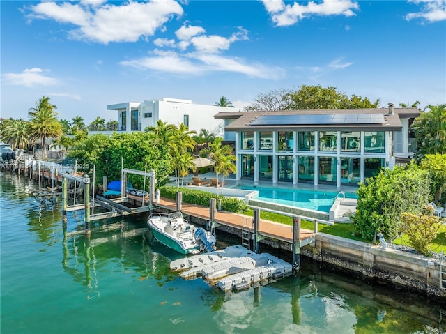 2055 NE 120th Rd, North Miami, FL 33181 - rear view of property featuring roof mounted solar panels, a water view, and an outdoor pool