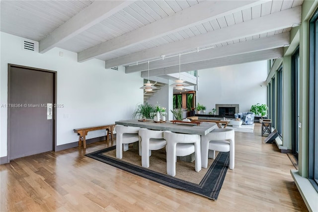 2055 NE 120th Rd, North Miami, FL 33181 - dining space featuring a fireplace, light wood finished floors, beamed ceiling, baseboards, and wooden ceiling