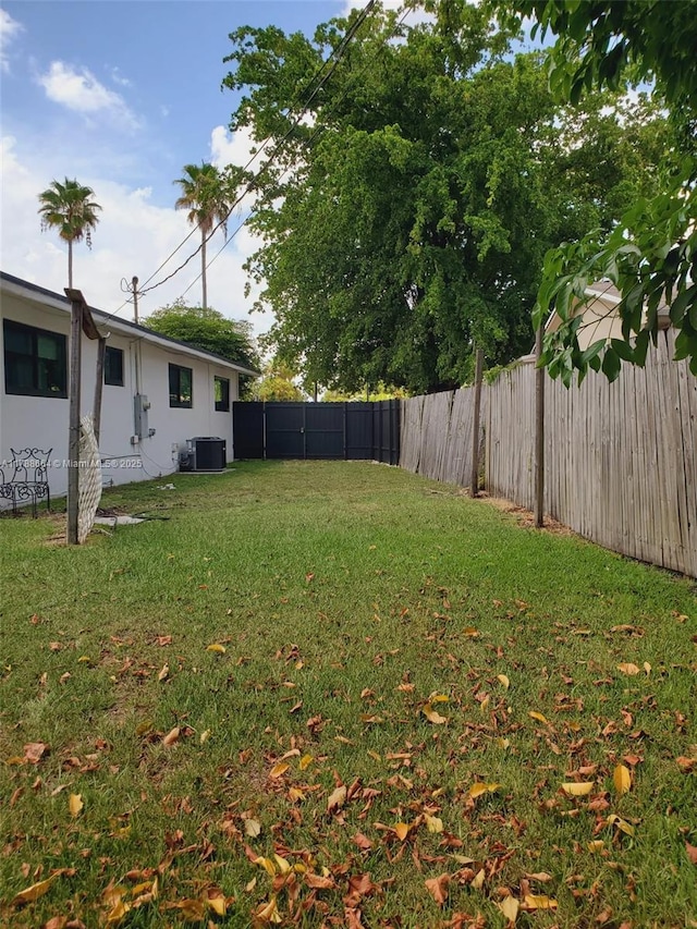 view of yard with a fenced backyard and central AC