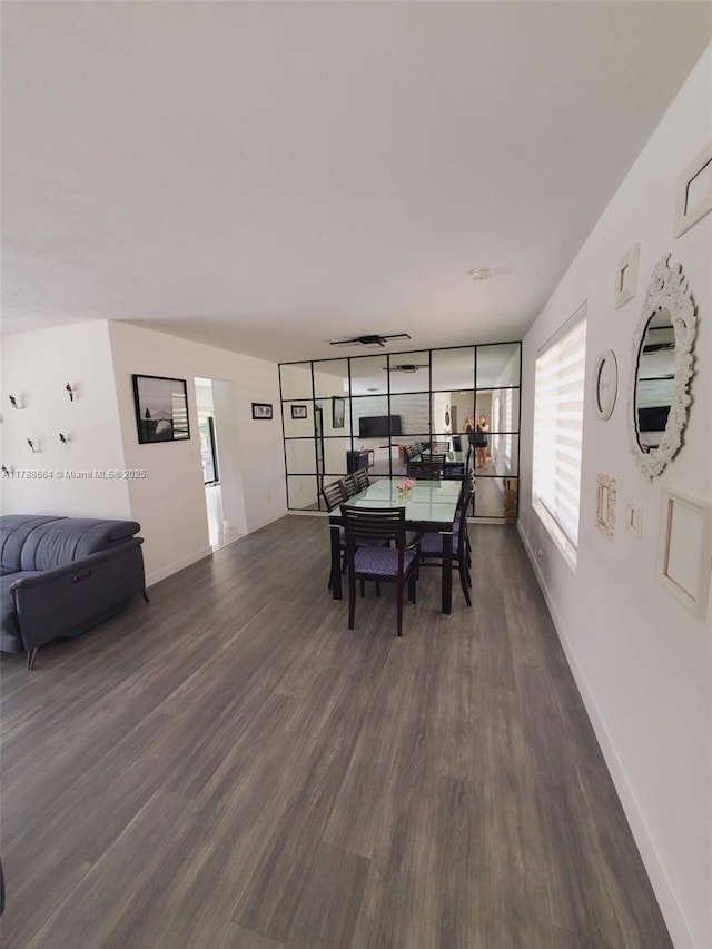 dining space with dark wood-type flooring and baseboards