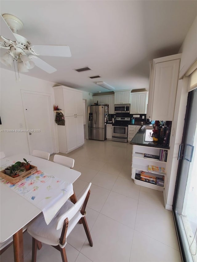 dining space featuring light tile patterned flooring, a ceiling fan, and visible vents