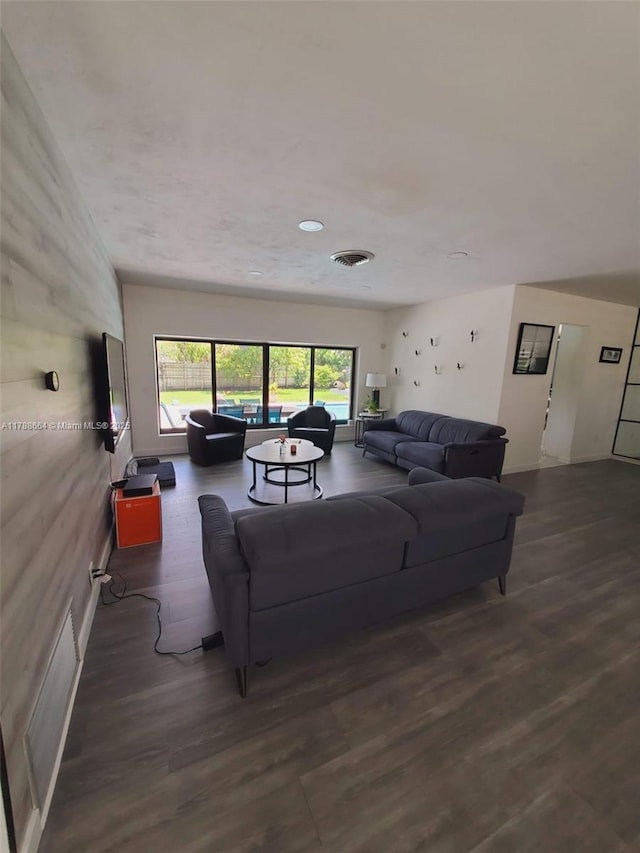 living area featuring visible vents and wood finished floors